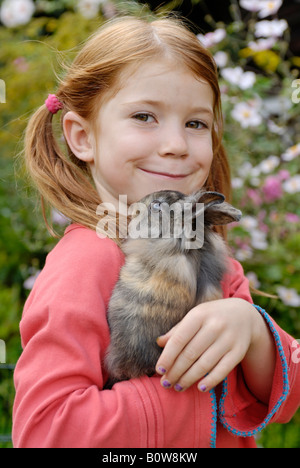 Bambina tenendo un Coniglio europeo (oryctolagus cuniculus) Foto Stock