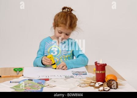 Bambina scrivendo il suo Natale la lista dei desideri per Babbo Natale Foto Stock