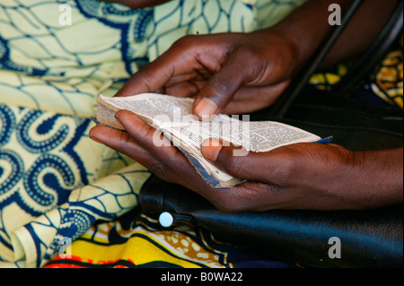 Mani tenendo un inno prenota presso un servizio di chiesa, Garoua, Camerun, Africa Foto Stock