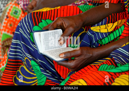 Mani tenendo un inno prenota presso un servizio di chiesa, Garoua, Camerun, Africa Foto Stock