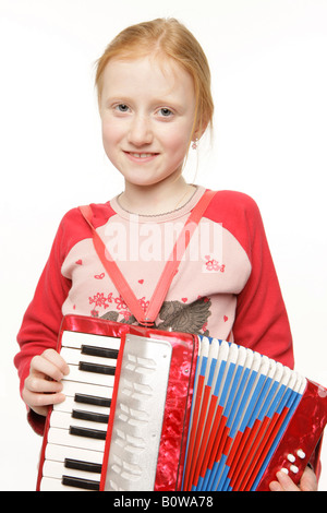 Sorridente 8-anno-vecchia ragazza che gioca il formare fisarmonica Foto Stock