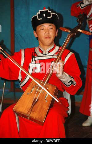 Musicista indossando vestiti tradizionali la riproduzione del morin khuur, matouqin o cavallo-testa fiddle, Mongolia, Asia Foto Stock
