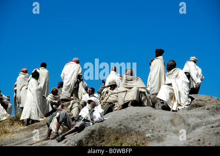 Ortodossa Etiope seguaci vestite di bianco capes raccolti su una roccia, Asheton Maryam Monastero, Lalibela, Etiopia, Africa Foto Stock