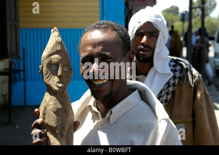 Uomo etiope tenendo un Konso figura di legno accanto alla sua testa, Addis Abeba o ad Addis Abeba, Etiopia, Africa Foto Stock