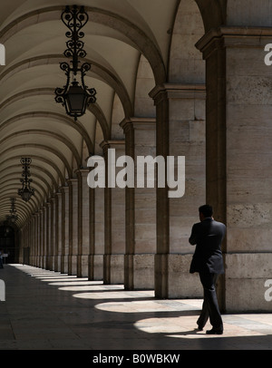 Uomo che cammina attraverso un corridoio arcuato, Lisbona, Portogallo Foto Stock