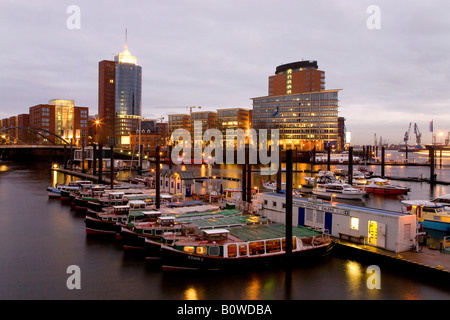 Lancia nel porto di Speicherstadt, architettura moderna sul Kehrwiederspitze, Amburgo, Germania, Europa Foto Stock