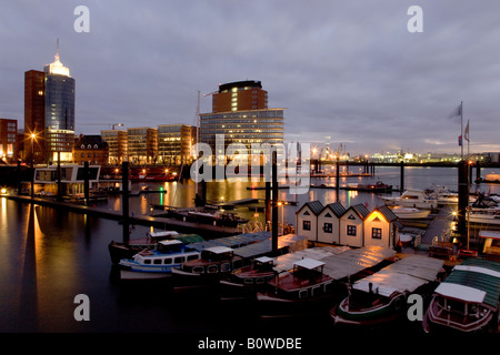 Lancia nel porto di Speicherstadt, architettura moderna sul Kehrwiederspitze, Amburgo, Germania, Europa Foto Stock