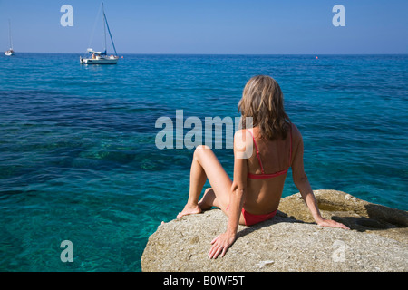 La donna a prendere il sole su una roccia, Spiaggia di San Andrea, Elba, Italia, Europa Foto Stock