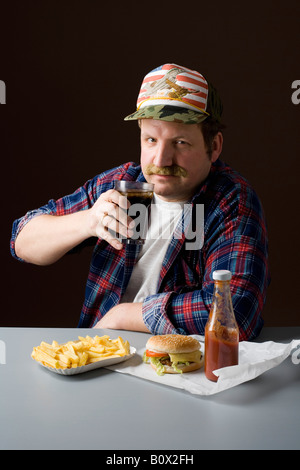 Stereotipi uomo americano con hamburger, patatine fritte e una cola Foto Stock