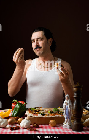 Stereotipato uomo italiano di mangiare la pizza e gesti con le mani Foto Stock