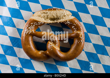 Ancora in vita di pretzel su un stereotipato blu tedesco controllato la tovaglia Foto Stock