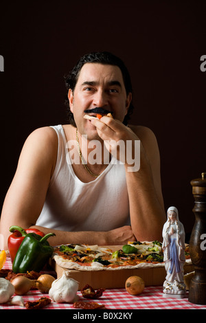 Stereotipato uomo italiana mangiare la pizza Foto Stock