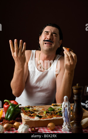 Stereotipato uomo italiano di mangiare la pizza e gesti con le mani Foto Stock