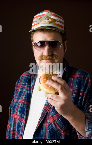 Stereotipi uomo americano tenendo un hamburger Foto Stock