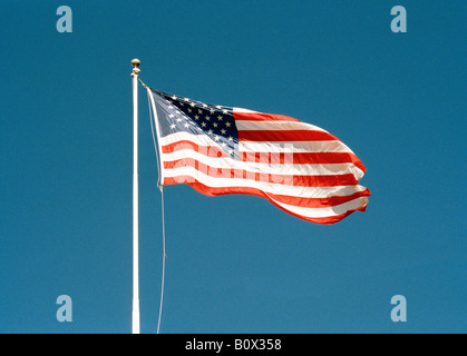 Una bandiera americana battenti contro un cielo blu chiaro Foto Stock