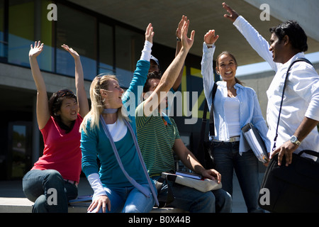 Gli studenti universitari ad alzare la mano in occasione di una riunione del campus Foto Stock