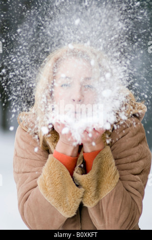 Austria, Salzburger Land, Altenmarkt, giovane donna lavori di soffiaggio della neve Off mano, ritratto Foto Stock