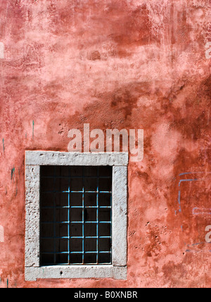 Nuda alla griglia o finestra in un vecchio muro Foto Stock