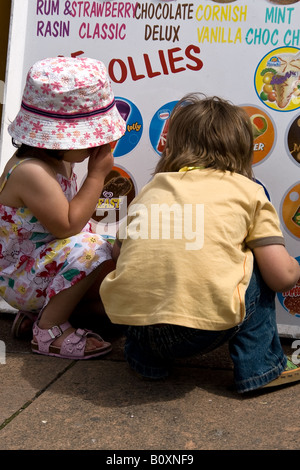 I bambini la scelta di gelato da un sandwich board Foto Stock