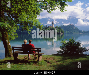 Giovane seduto su un banco di lavoro accanto al lago di Bled Bled, Gorenjska, Slovenia. Foto Stock
