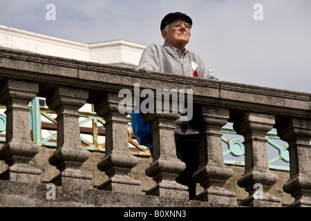 Il vecchio uomo che guarda al mare sul lungomare di Brighton Foto Stock