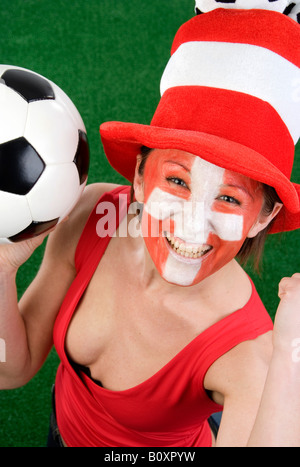 Carino donna in una parte superiore rossa come la Svizzera ventola, tifo con il cappello e il calcio Foto Stock