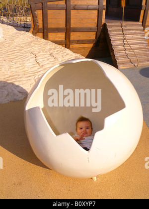 Bambino in uovo rotto su un parco giochi Foto Stock