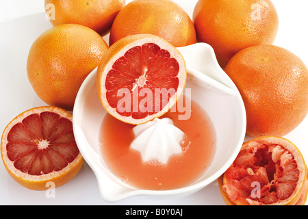 Fette di pompelmi sulla spremitore succo di frutta Foto Stock