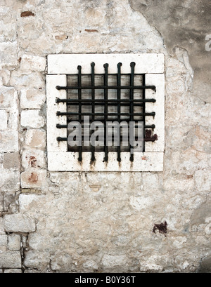 Nuda alla griglia o finestra in un vecchio muro Foto Stock