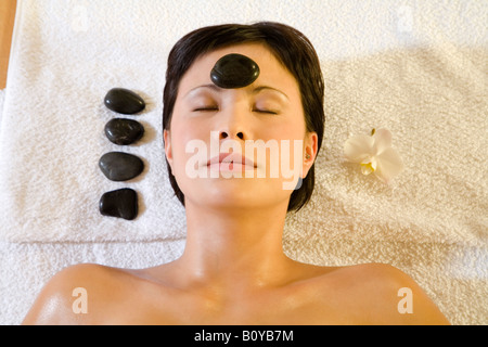Giovane donna in spa, ricevendo la terapia lastone Foto Stock