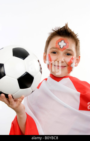 Il ragazzo, rouged come calcio svizzero ventola, con il calcio in mano e bandiera Foto Stock