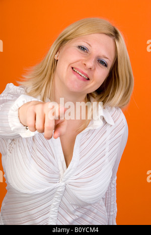 Giovane donna bionda che punti a qualcosa di Foto Stock