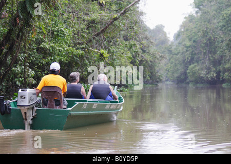 I turisti tenendo gita in barca lungo il fiume nella giungla, Sukau, Sabah Malaysian Borneo Foto Stock