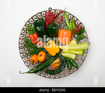 Varietà di coloratissimi peperoncino su una piastra decorativa Foto Stock