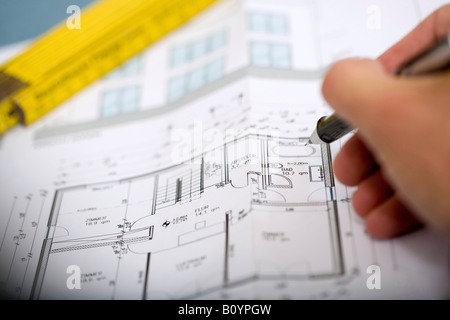 Mano d'uomo rivolto a blueprint con penna Foto Stock