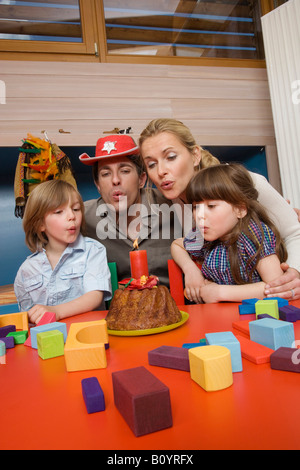 Famiglia festa di compleanno, famiglia soffiando candela su torte, ritratto Foto Stock