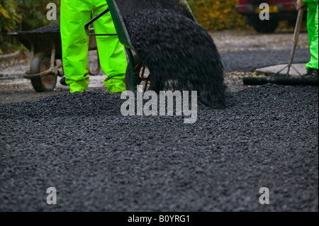 Il ribaltamento di asfalto su un nuovo passo carraio tarmacadam Foto Stock