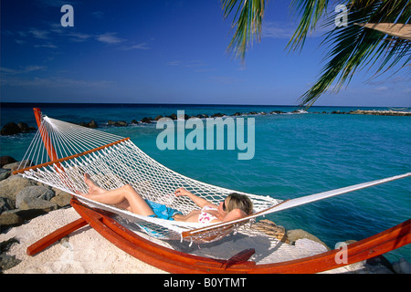 Giovane donna getta in una amaca isola rinascimentale Aruba Foto Stock