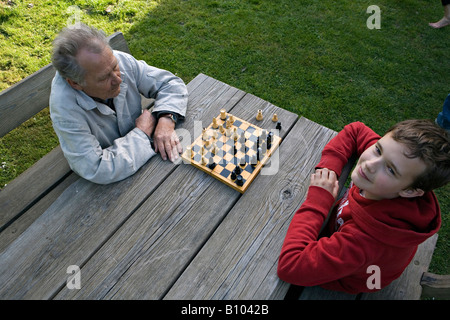Nonno e ragazzo giocando una partita a scacchi in giardino Foto Stock