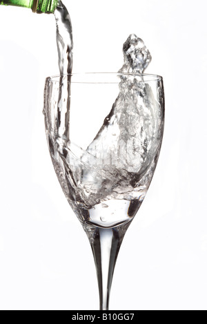 L'acqua versata in un bicchiere con una fettina di limone Foto Stock