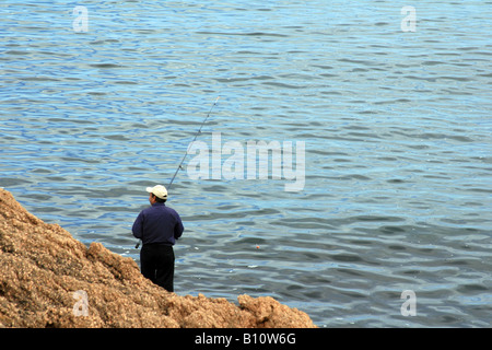 L'uomo la pesca nella costa della città di La Coruña, Galizia, Spagna. Foto Stock