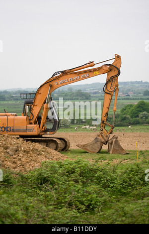 Escavatore cingolato case 9013 su cingoli che spostano la terra in un'azienda agricola in primavera. Sussex, Inghilterra, Regno Unito Foto Stock