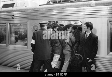 Feb 25, 2004 - pendolari essendo spinto in un treno che viaggia da Yokohama a Tokyo presso il Morning Rush Hour. Foto Stock