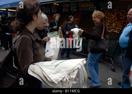 Volontari nella parte anteriore del fairway supermercato in New York dare via riutilizzabile sacchi di tela per gli amanti dello shopping per sostituire i sacchetti di plastica Foto Stock