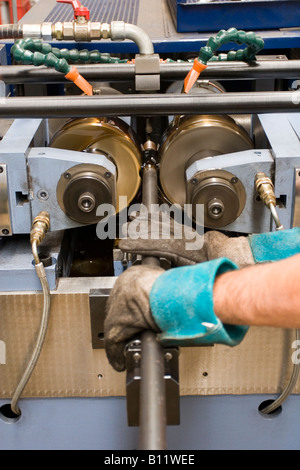 Operaio industriale le mani cilindrica di elaborazione con barra in metallo e attrezzature industriali Foto Stock