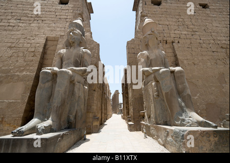 Colossi in ingresso alla corte di Ramses II, Tempio di Luxor, Luxor, la Valle del Nilo, Egitto Foto Stock