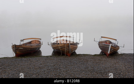 Tre barche a remi in una nebbiosa mattina a Keswick, Cumbria, England, Regno Unito Foto Stock