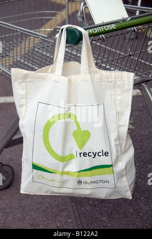 Sacchetti eco riutilizzabili in cotone con logo i recycle sul carrello per supermercati Islington London UK Foto Stock