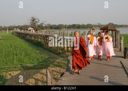 Monaci e monache U Bein's Bridge, la più lunga del mondo ponte in teak, Amarapura, Myanmar (Birmania) Foto Stock