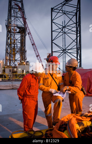 Lavoratori di olio a discutere il lavoro. Ensco rig. Campo Natuna. Mare Mare della Cina del Sud. Indonesia. Foto Stock